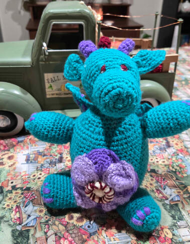 This is Peanut! He is a river dragon and he loves flowers. He was crocheted with acrylic yarn. He is not for sale, but I do sell crocheted dolls! See VGen for pricing!